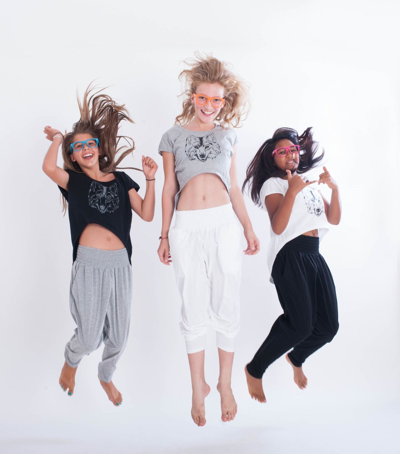 Three young women jumping in a white studio