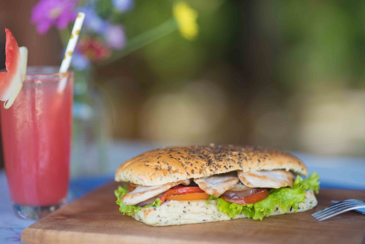 Sandwich on a board with a pink drink
