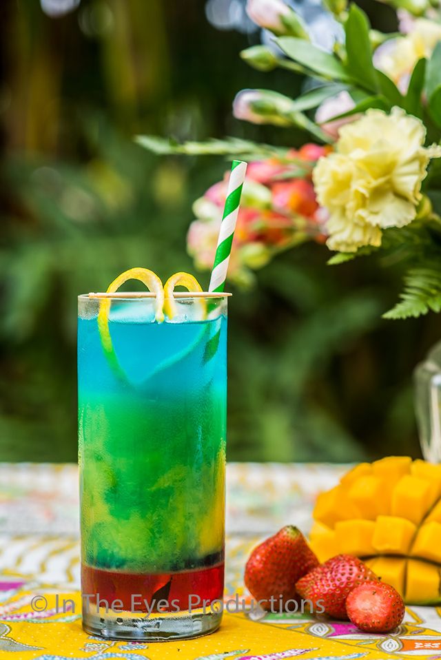 Layered blue, green and yellow cocktail with flowers