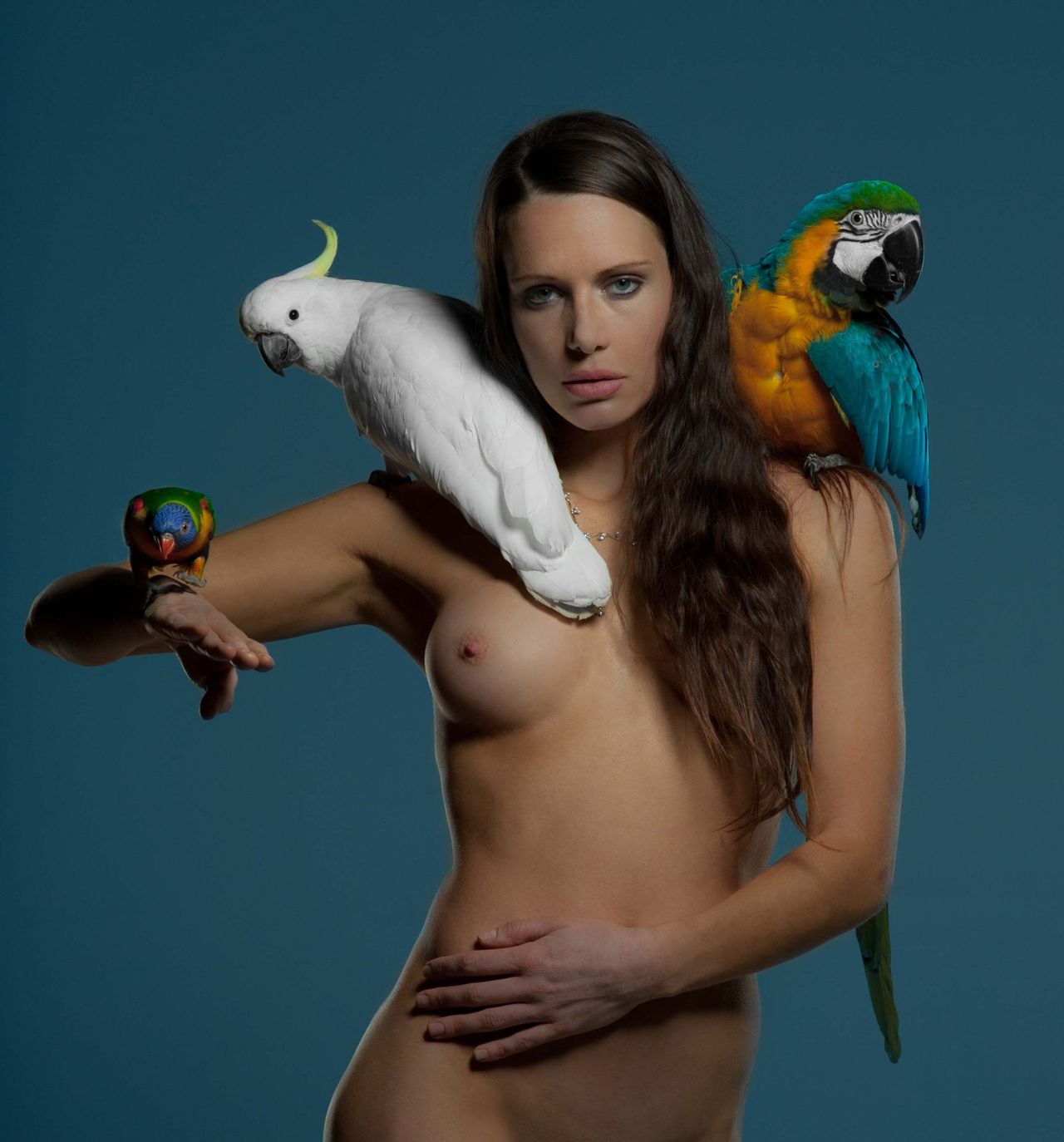 Artistic portrait of a woman with a cockatoo and a macaw on her shoulders