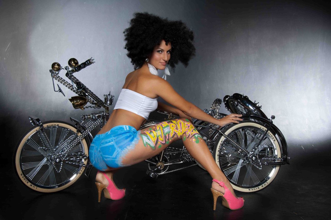 Woman with an afro posing on a custom motorbike