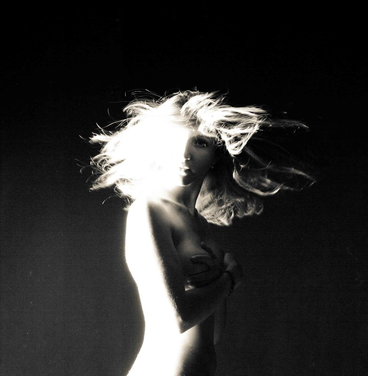 High-contrast black-and-white silhouette of a woman with backlit hair