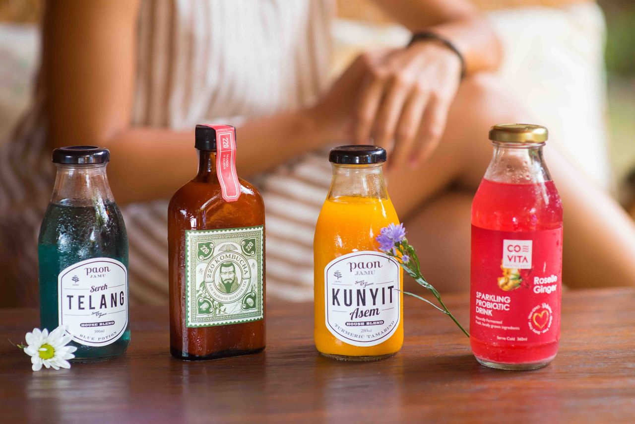 Four bottles of juice and drinks lined up on a table