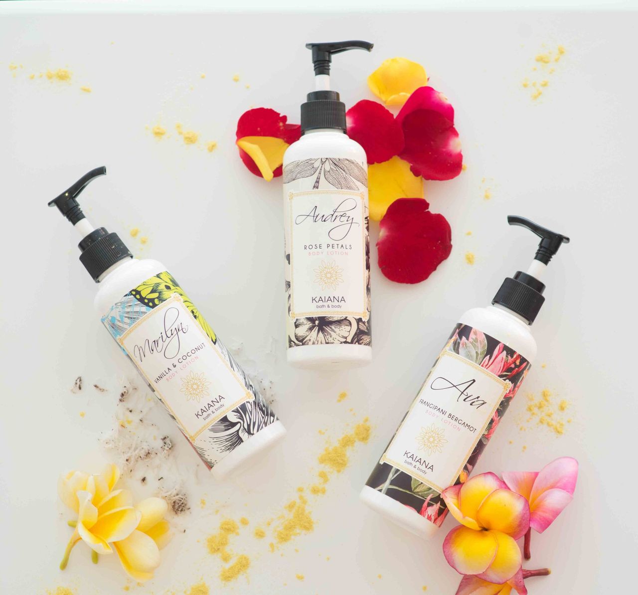 Three pump bottles of body lotion with tropical flowers
