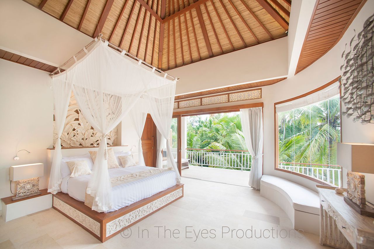 Bedroom with a draped canopy bed under a timber-lined vaulted ceiling