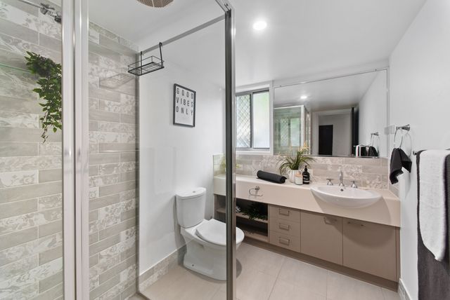 Bathroom with a frameless glass shower and a timber vanity