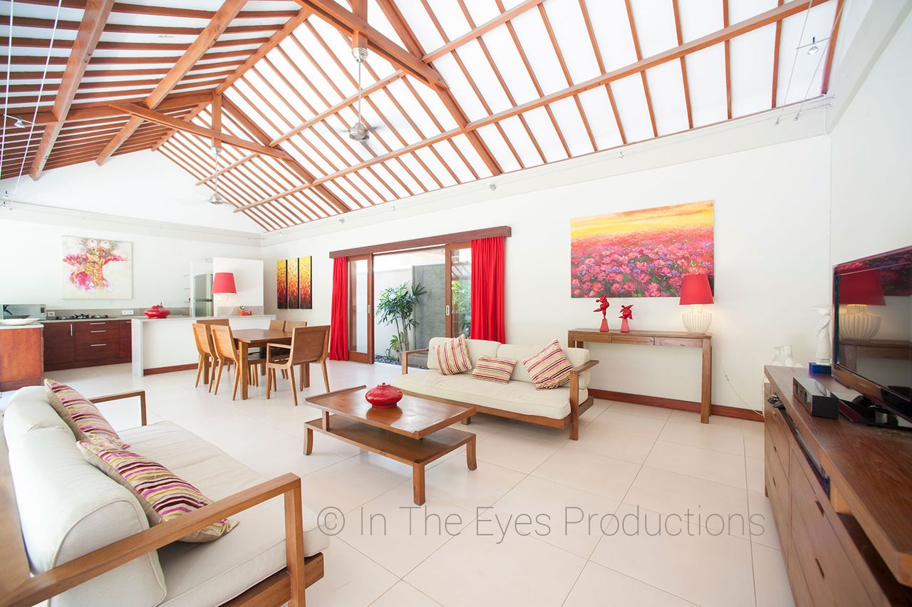 Living and dining area under a timber-beamed skylight roof