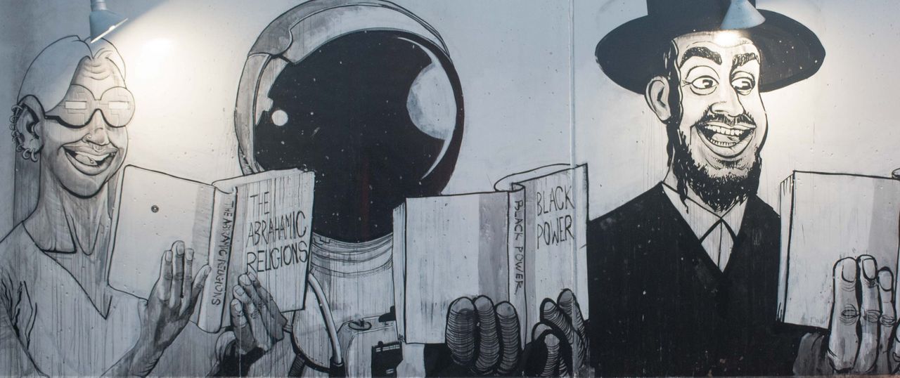 Black-and-white mural of cartoon characters reading books